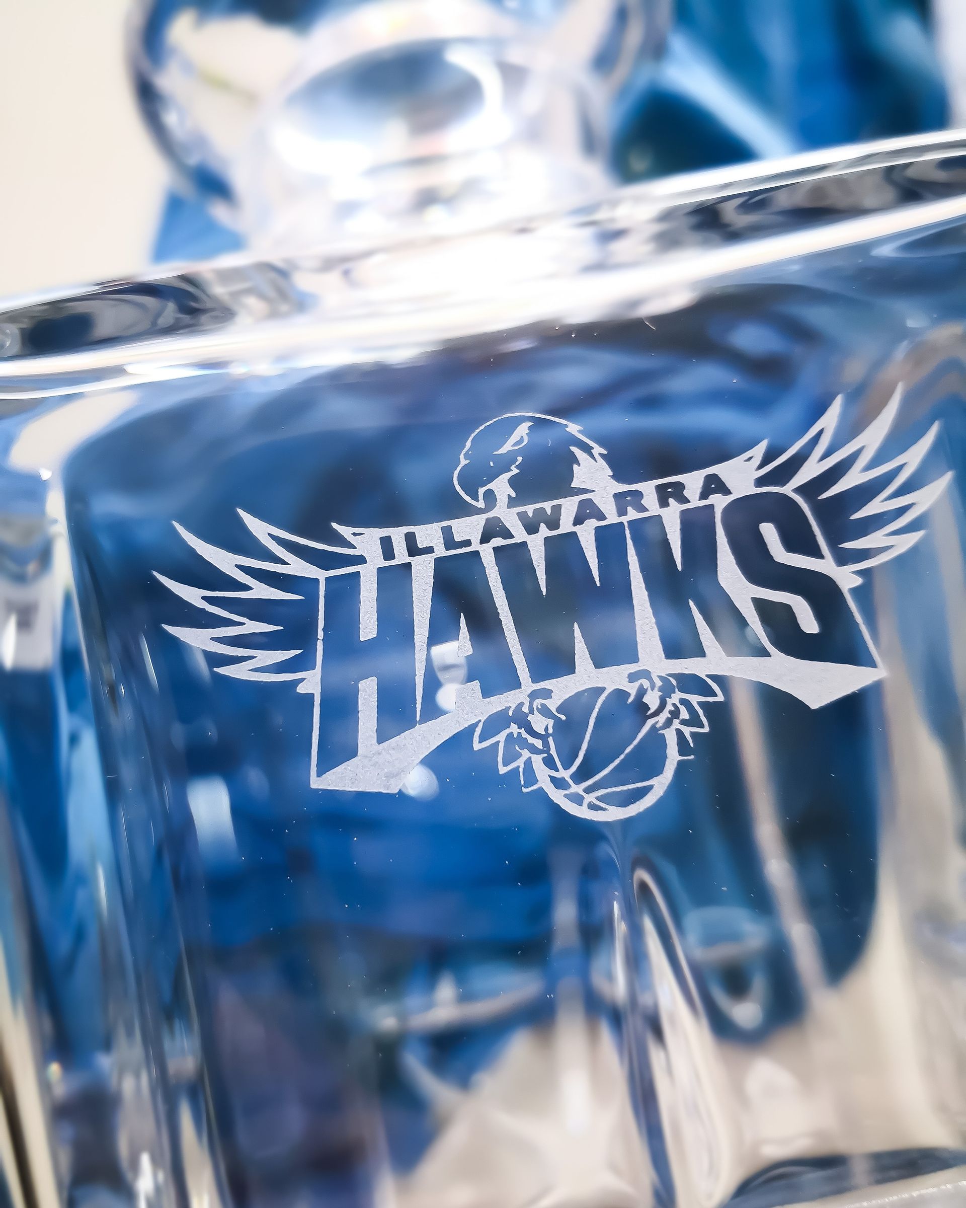 A Close Up of a Glass With An Illawarra Hawks Emblem Engraved — NMTG Engraving in Wollongong, NSW
