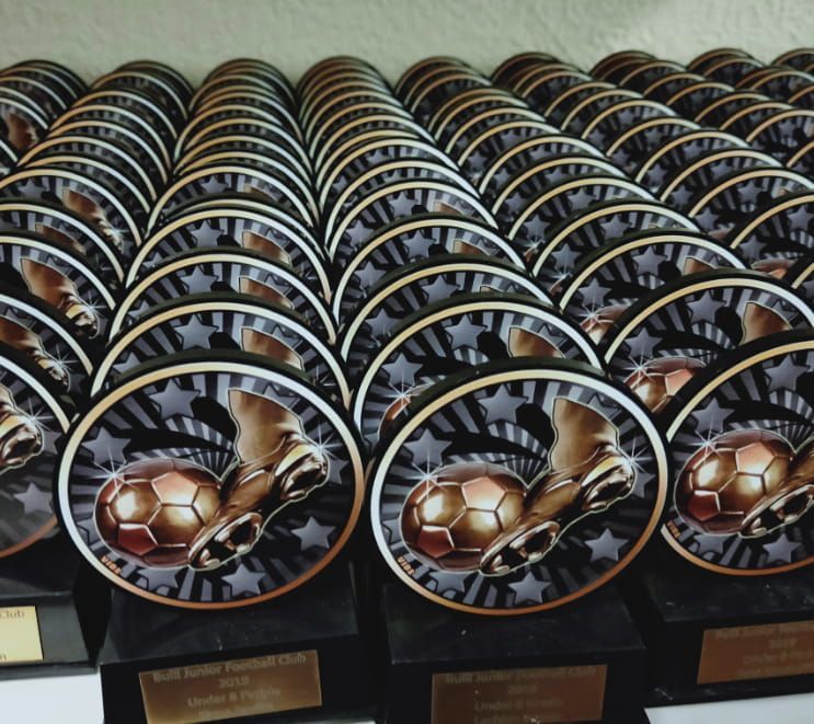 A Bunch of Soccer Trophies Are Lined Up on a Table — NMTG Engraving in Wollongong, NSW