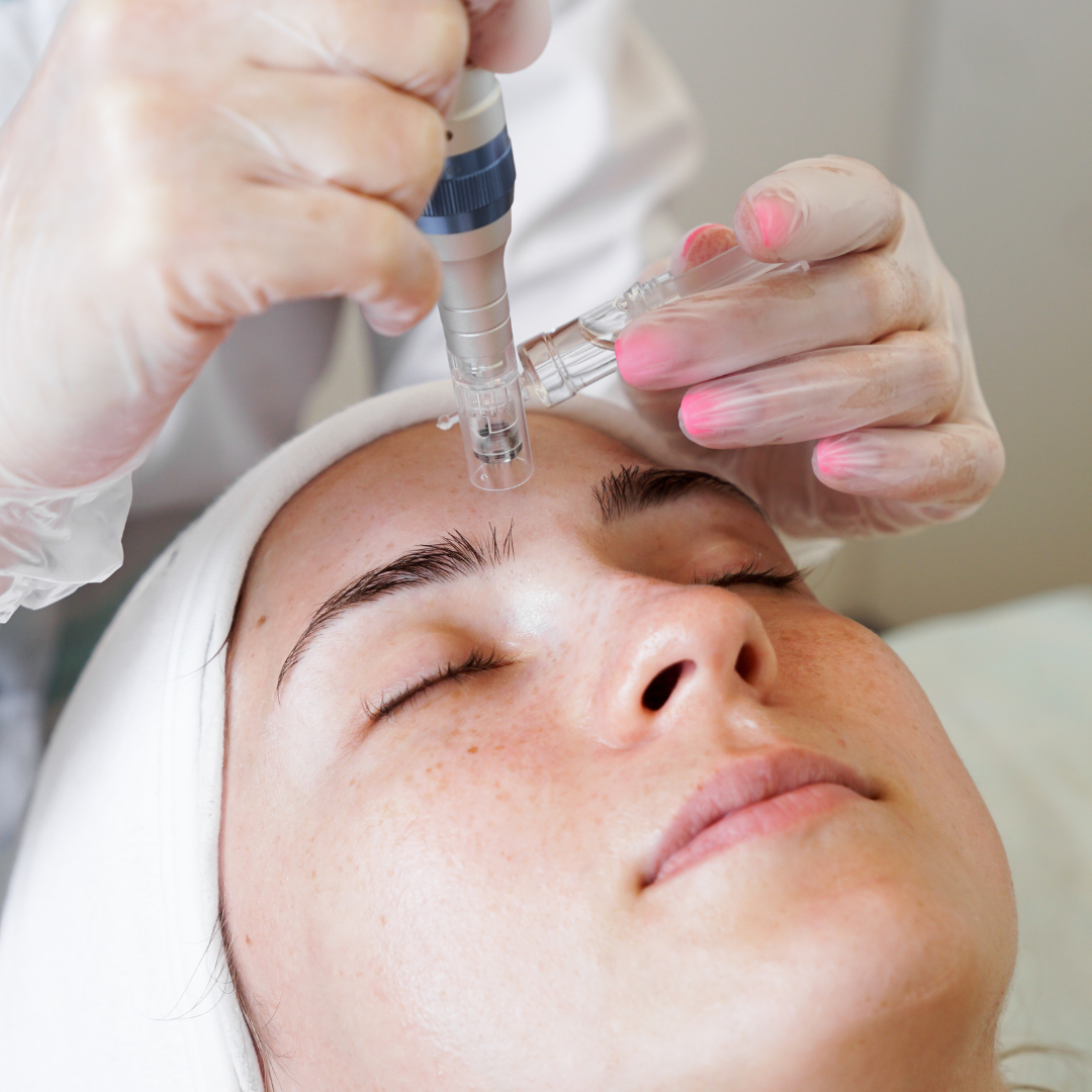 A woman with pink nails is getting a treatment on her face