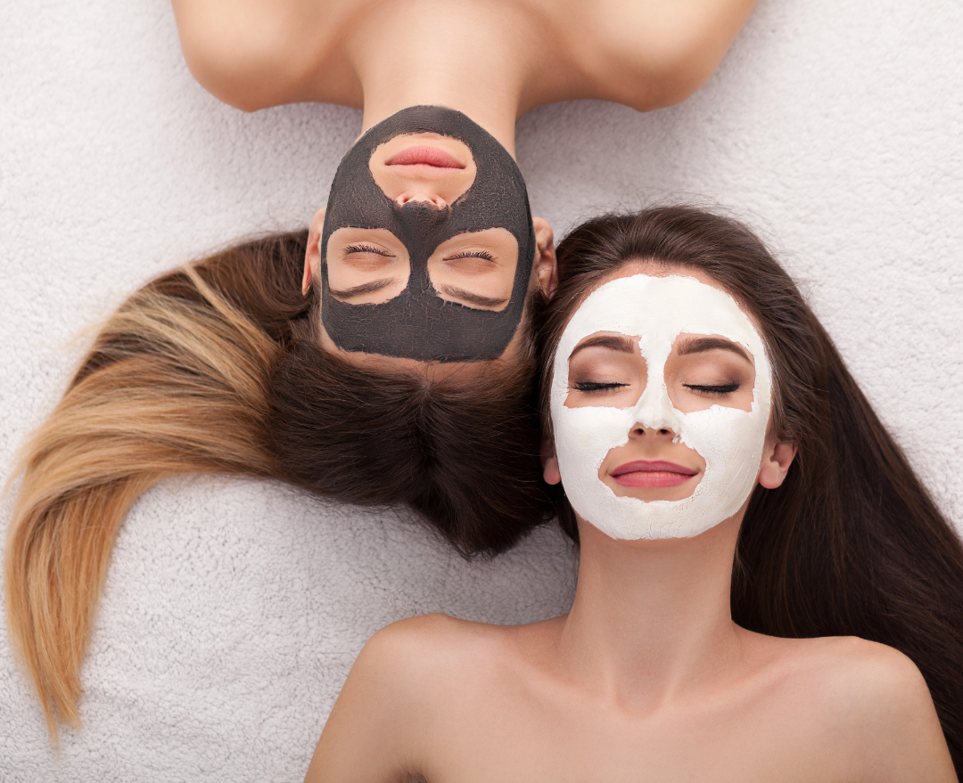 Two women are laying next to each other with facial masks on their faces.