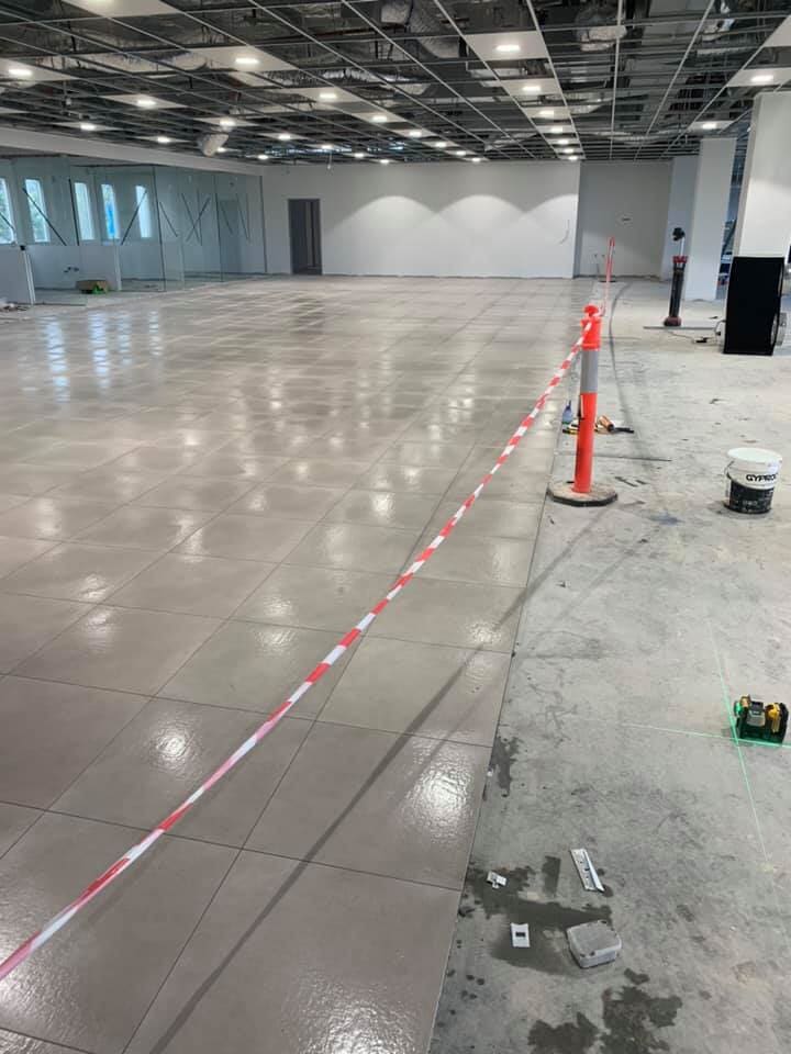 Empty Commercial Space Installing Tile Flooring — Wall And Floor Tiling in Central Coast, NSW