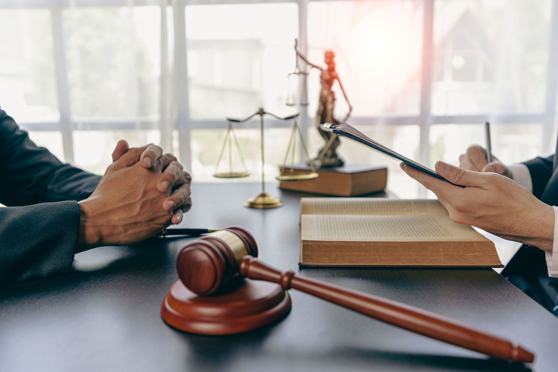 Un uomo in giacca e cravatta è seduto a una scrivania con un computer portatile e una bilancia della giustizia.