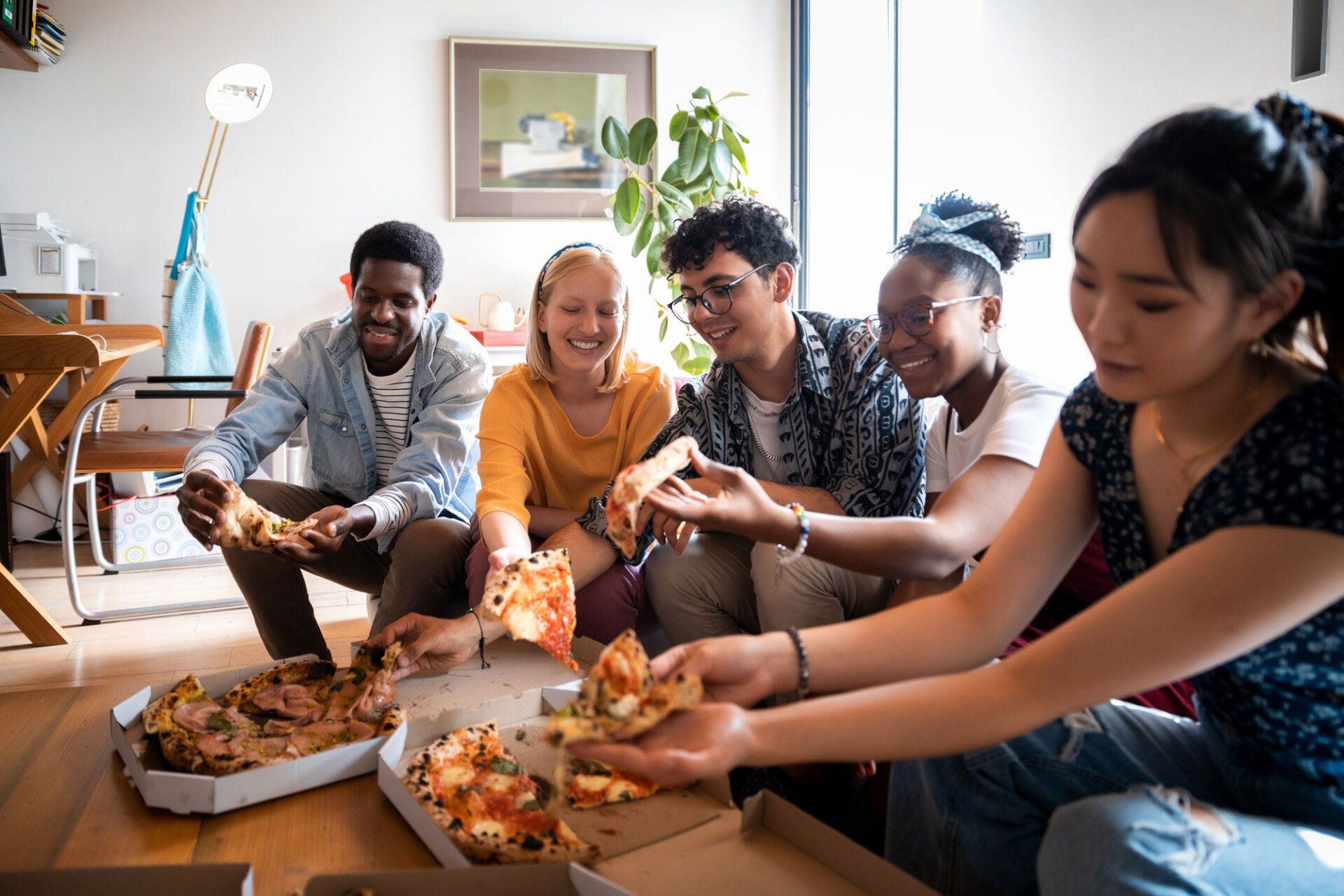 Photo of Students Sharing a Pizza at Home