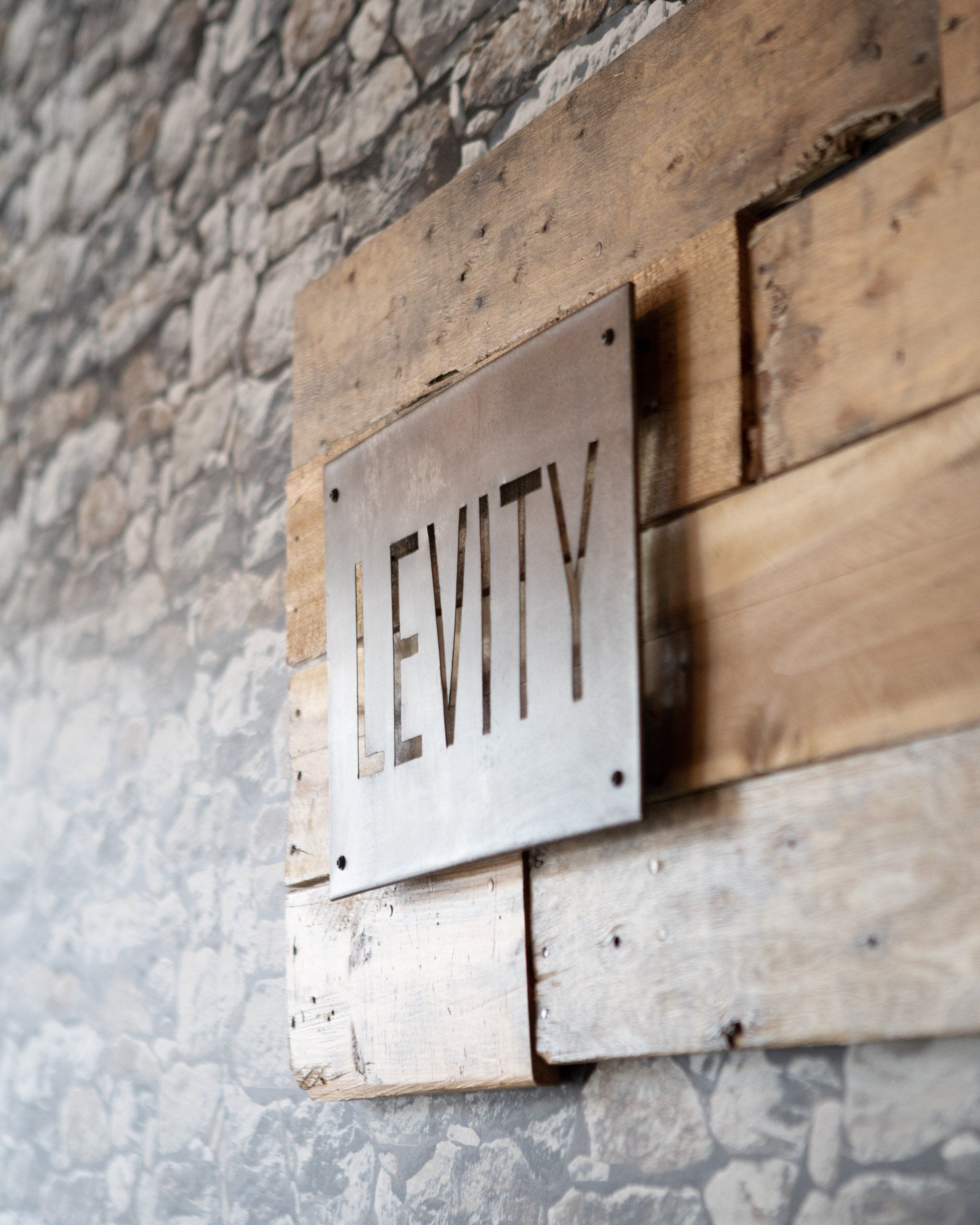 A sign on a wooden wall that says levity
