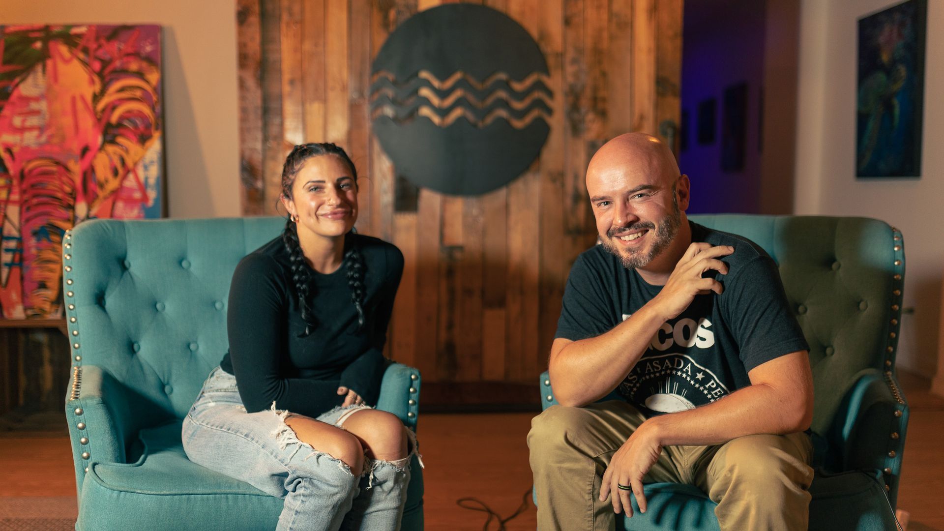 A man and a woman are sitting on a blue couch.
