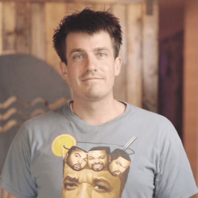 A man wearing a t-shirt with three faces on it