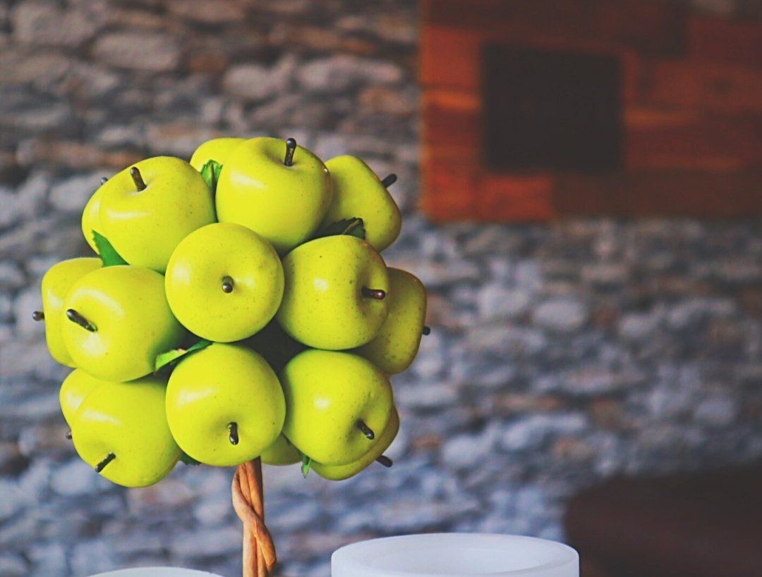 A bunch of yellow apples are sitting on a table
