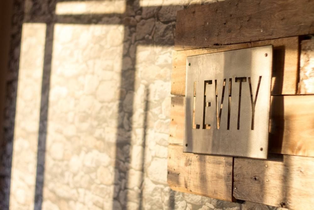 A sign on a wooden wall that says levity