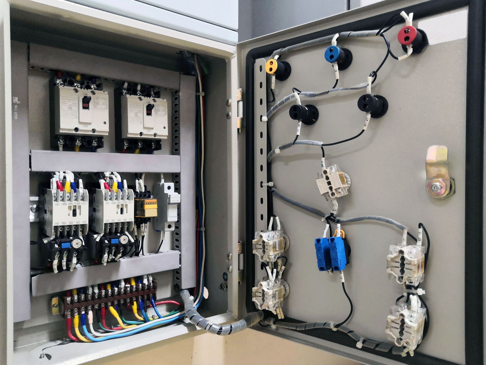 The inside of a electrical box with a lot of wires coming out of it.