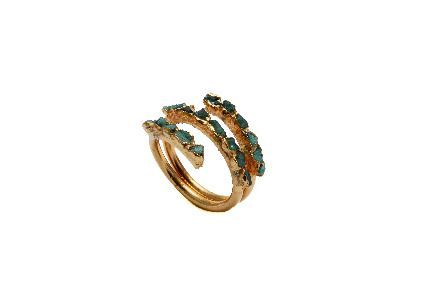 Un anillo de oro con piedras verdes sobre fondo blanco.
