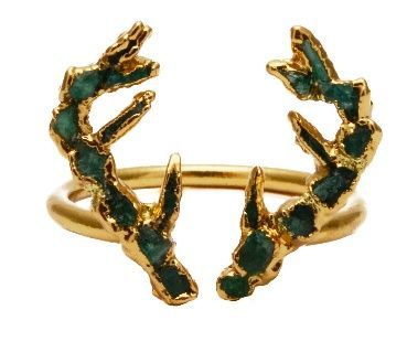 Un anillo de oro con piedras verdes.