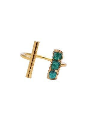 Un anillo de oro con tres piedras verdes sobre fondo blanco.