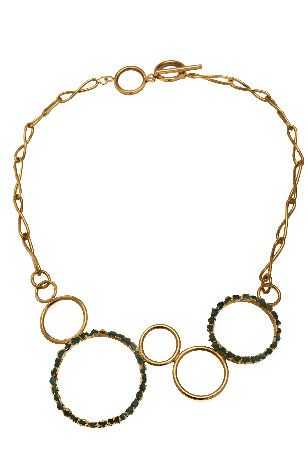Un collar de oro con círculos en una cadena sobre un fondo blanco.