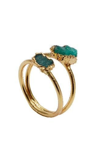 Un anillo de oro con dos piedras verdes.