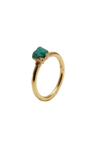 Un anillo de oro con una piedra verde en el centro sobre un fondo blanco.