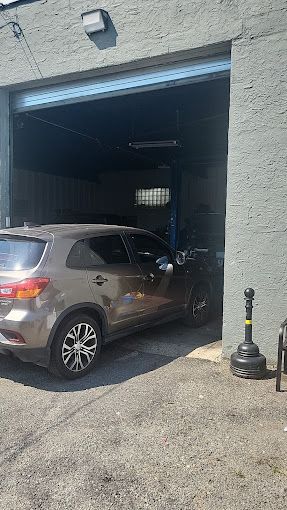A car is parked in front of a garage door.