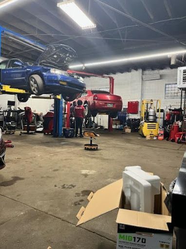 Two cars are being worked on in a garage.