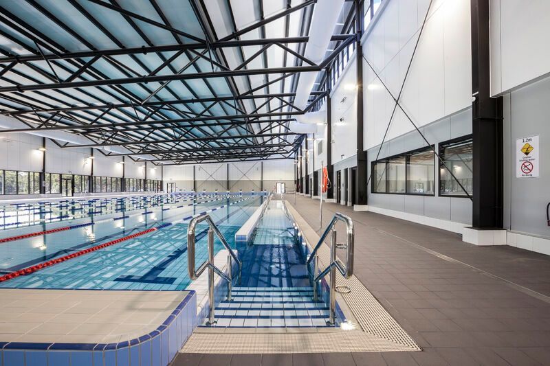A large indoor swimming pool with stairs leading to it