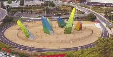 An aerial view of a roundabout with a sculpture in the middle of it.