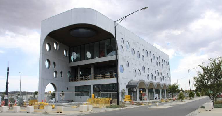 A large white building with a lot of windows is being built.