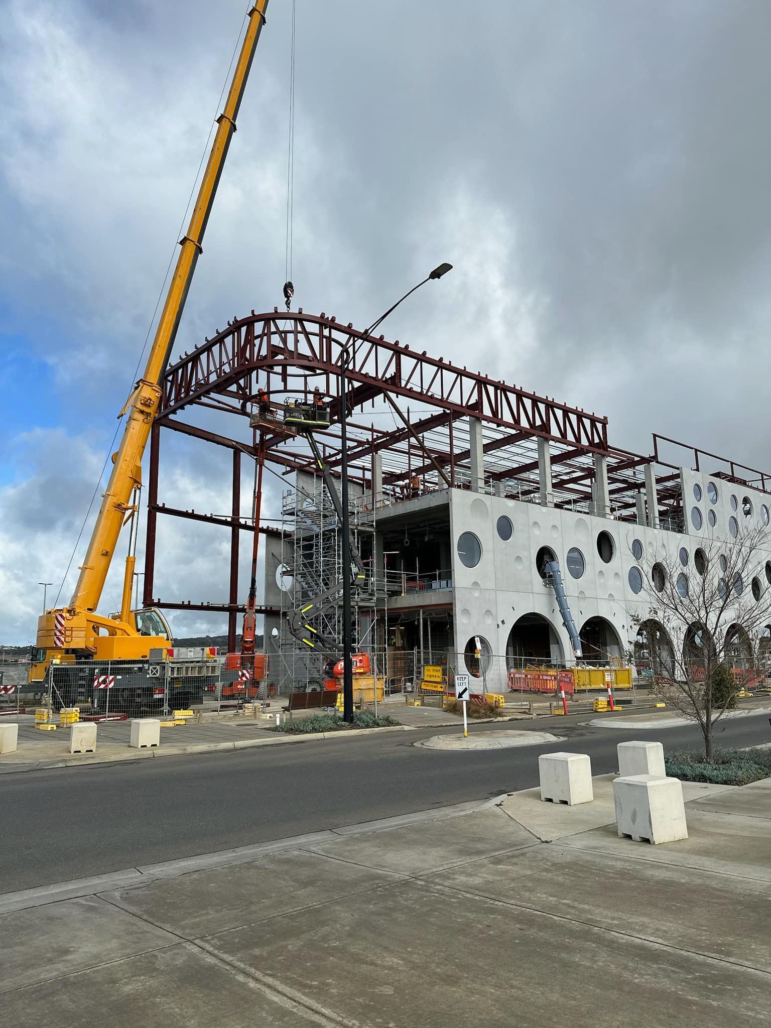 A large building under construction with a crane in front of it.