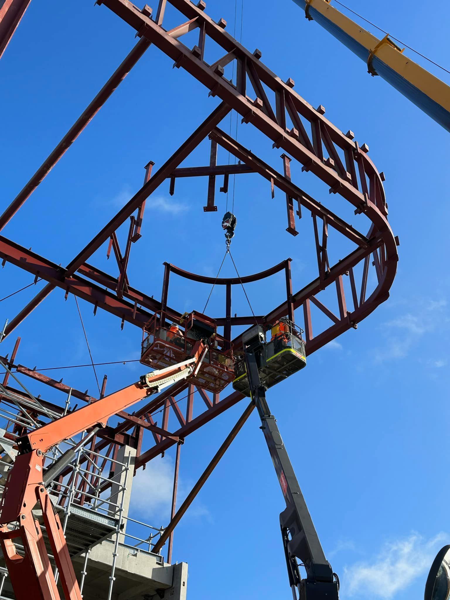 A roller coaster under construction with a blue sky in the background
