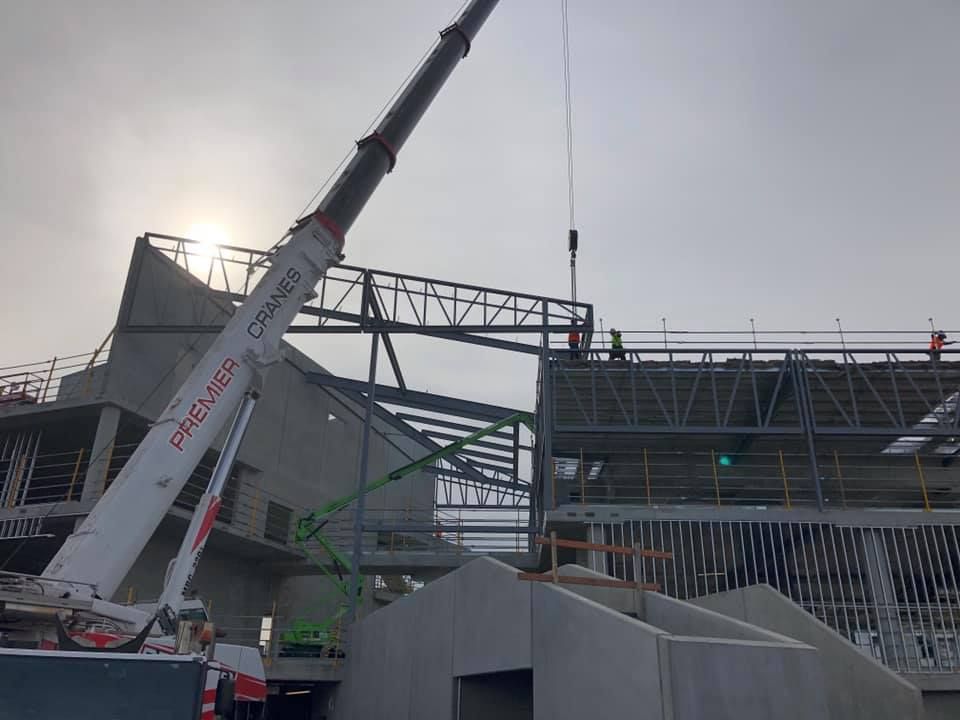 A large crane is sitting on top of a building under construction.