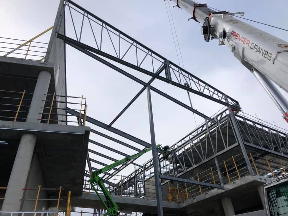 A large crane is lifting a large metal structure