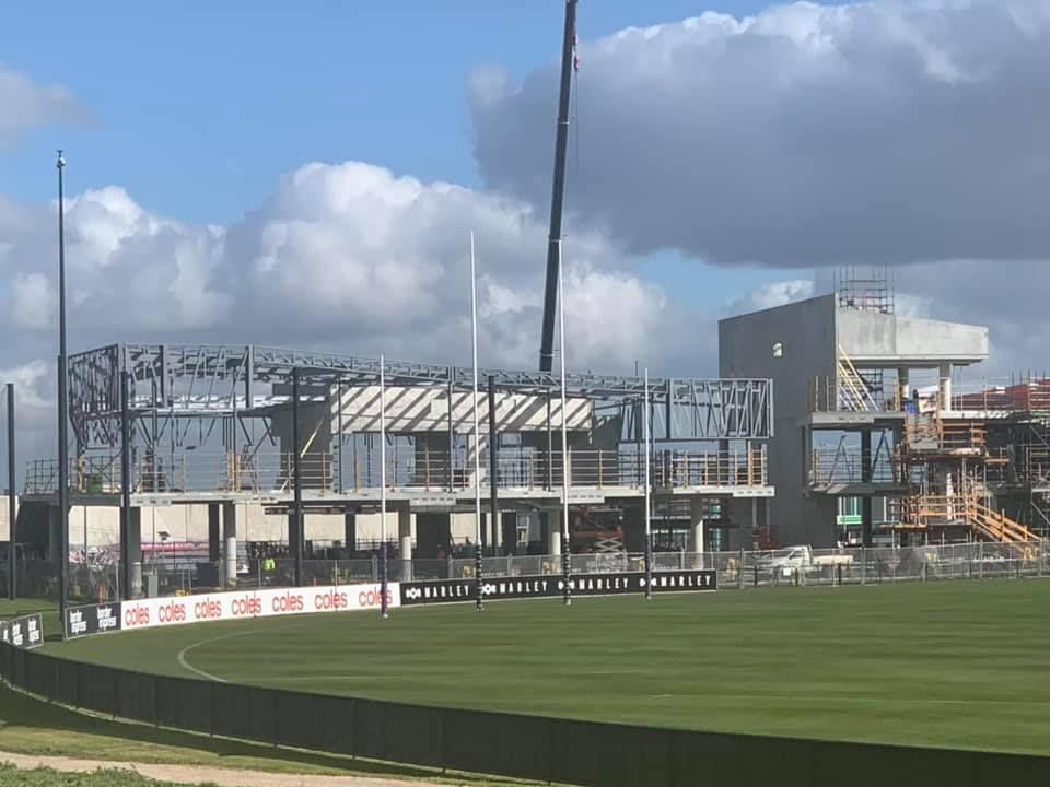 A large building is being built on top of a soccer field.