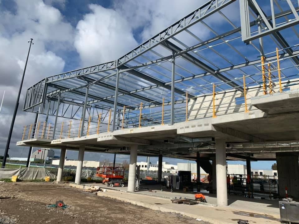 A large building under construction with a blue sky in the background.