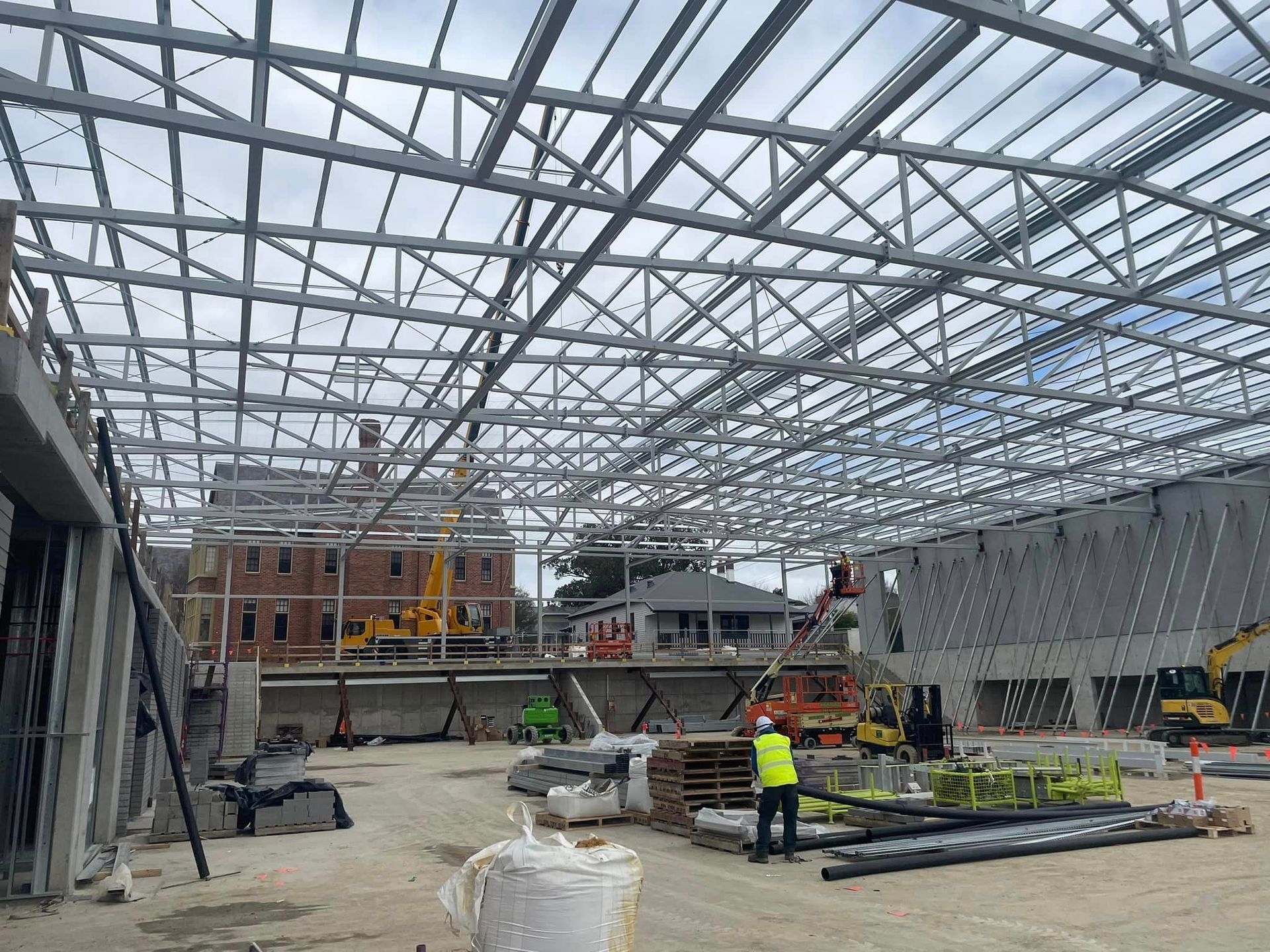 A large metal structure is being built on a construction site.