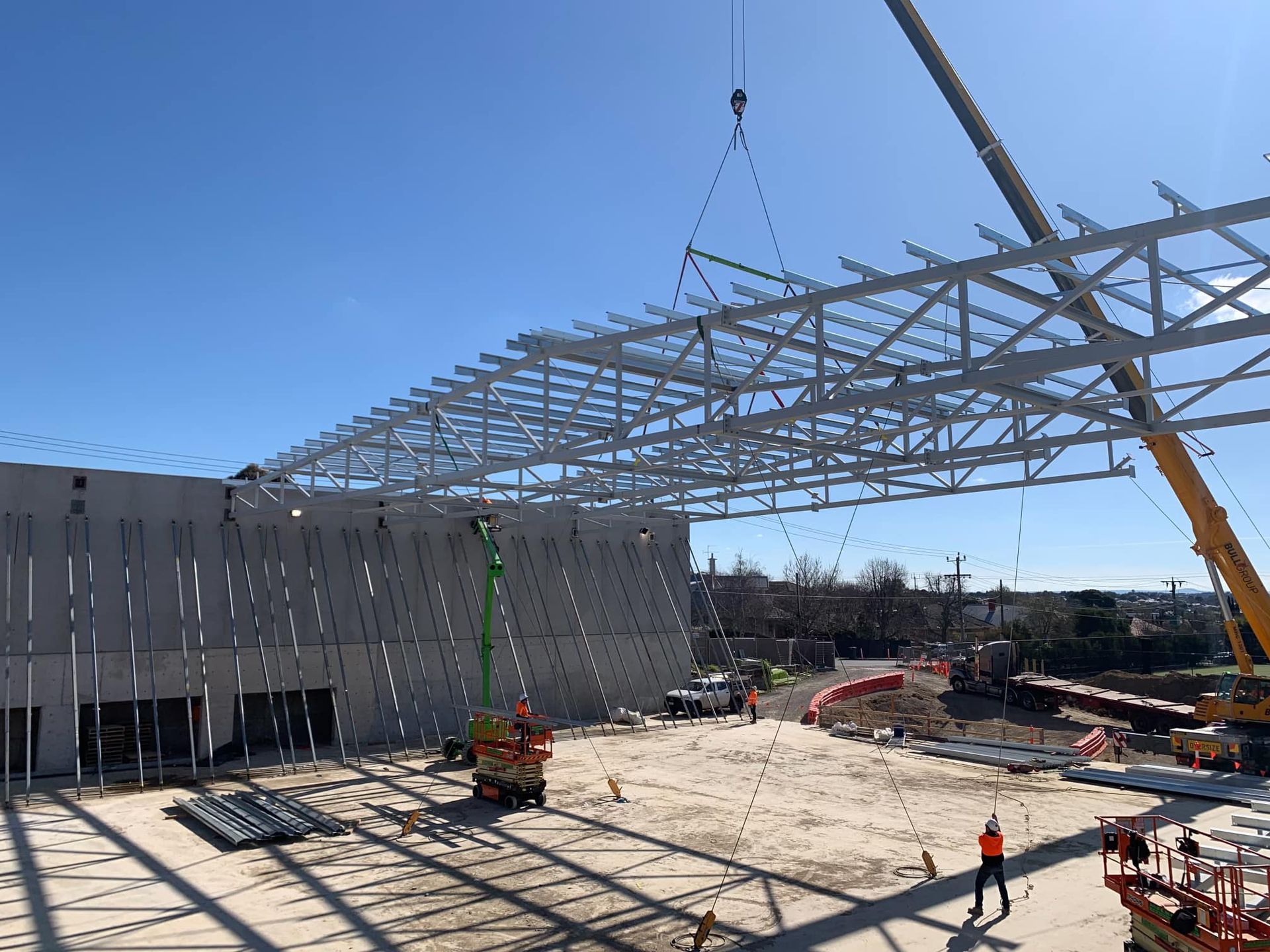 A crane is lifting a metal structure on top of a building.