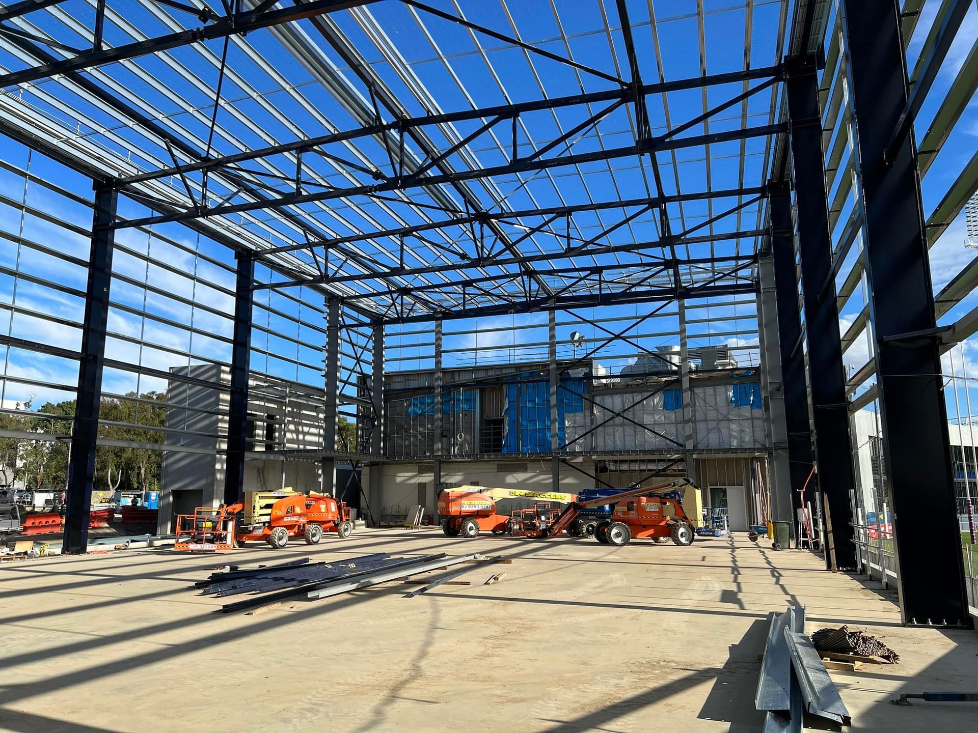 A large metal structure is being built on a construction site.
