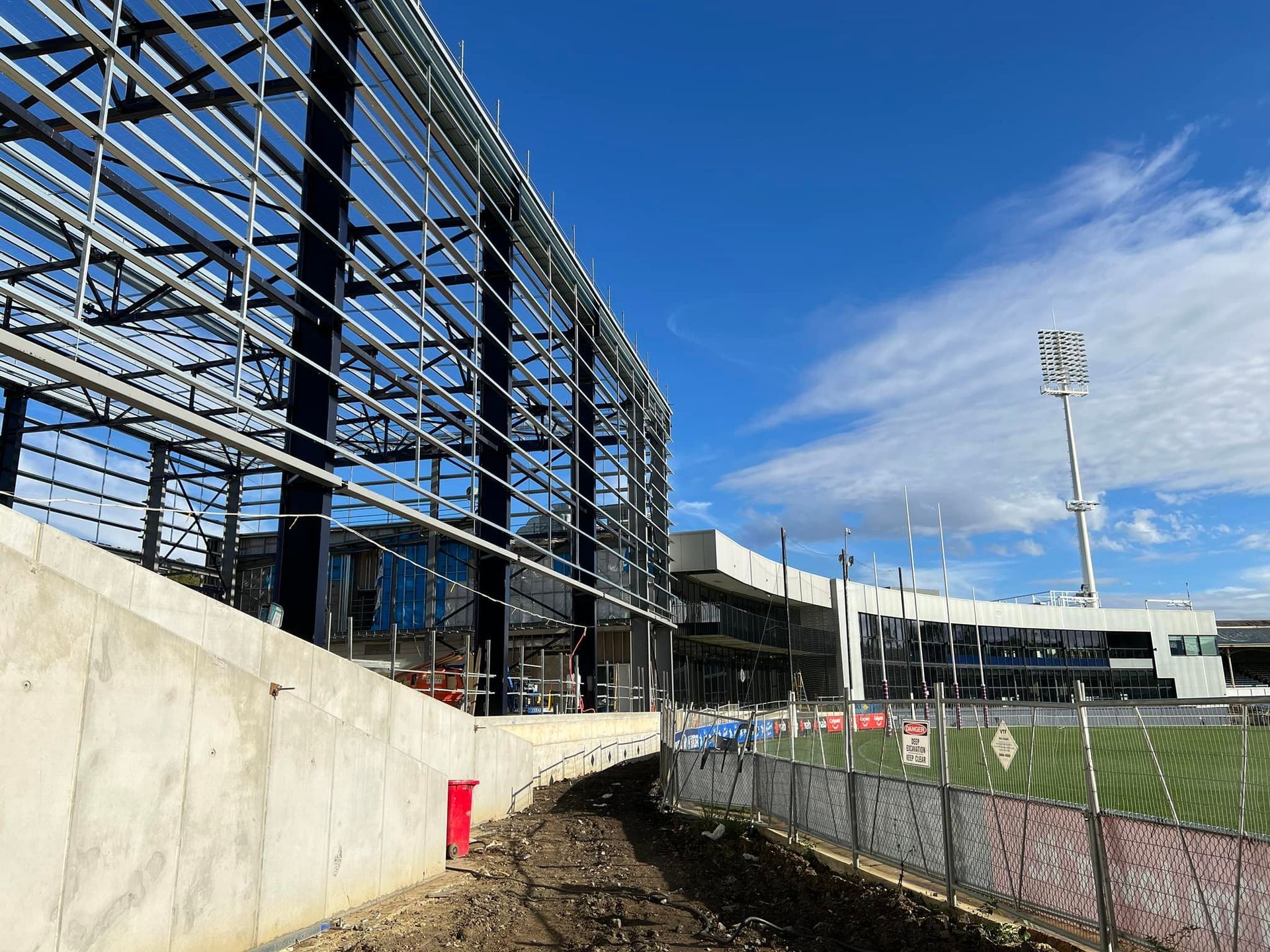 A large building under construction with a fence in front of it.