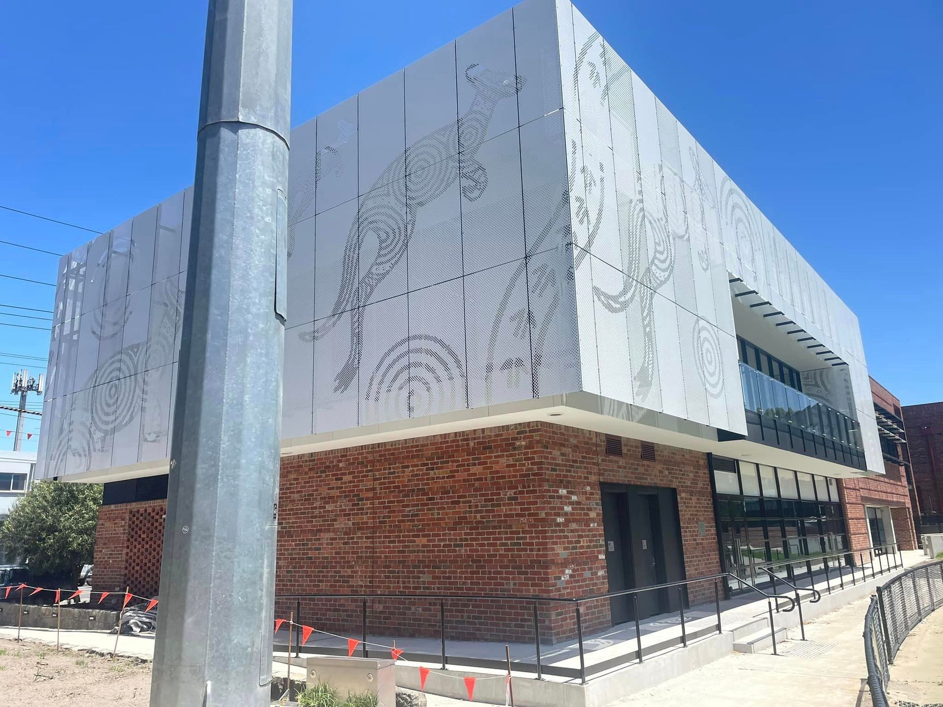 A large building with a metal pole in front of it.