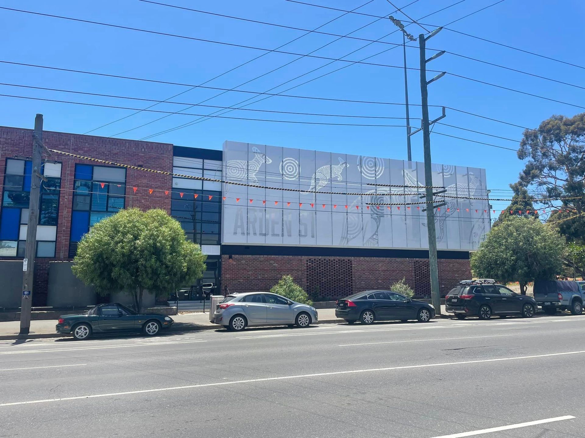 Cars are parked on the side of the road in front of a building.