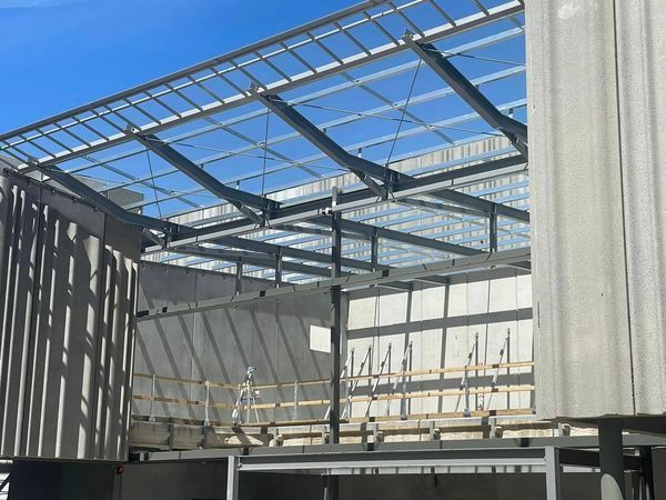 A building under construction with a blue sky in the background.