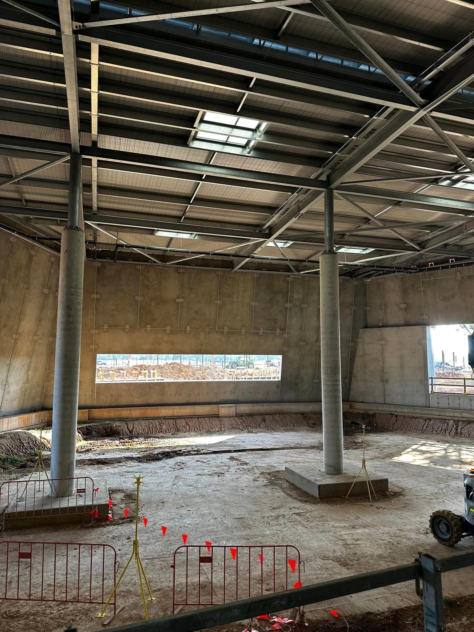 The inside of a building under construction with a large window in the ceiling.