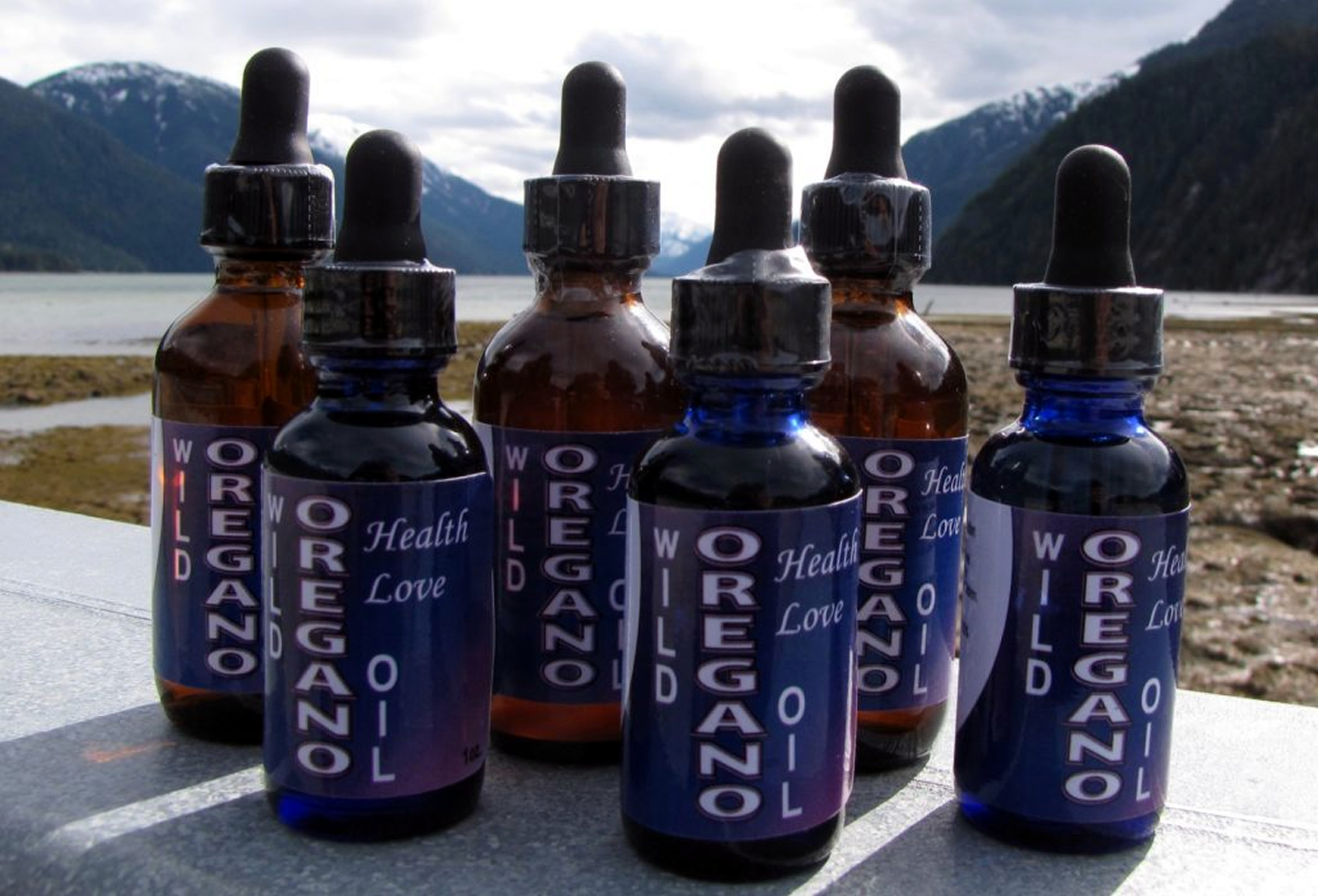 several bottles of oregano oil are lined up on a table