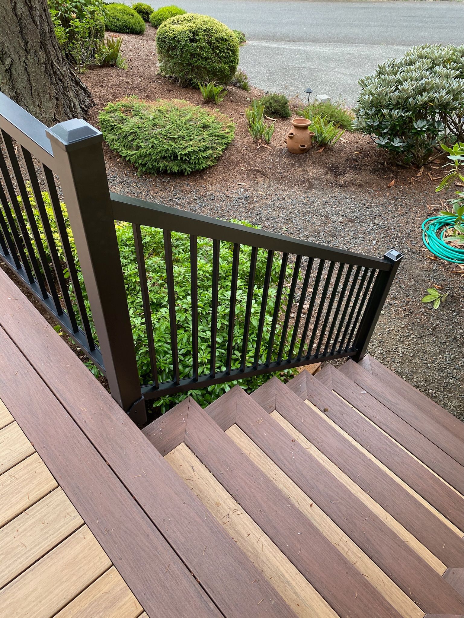 A wooden deck with stairs is in front of a house.