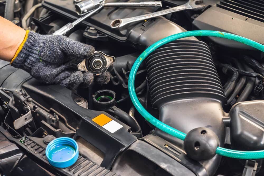a Person is Working on the Radiator of a Car — Wayne Boylett Mechanical In Bungalow, QLD