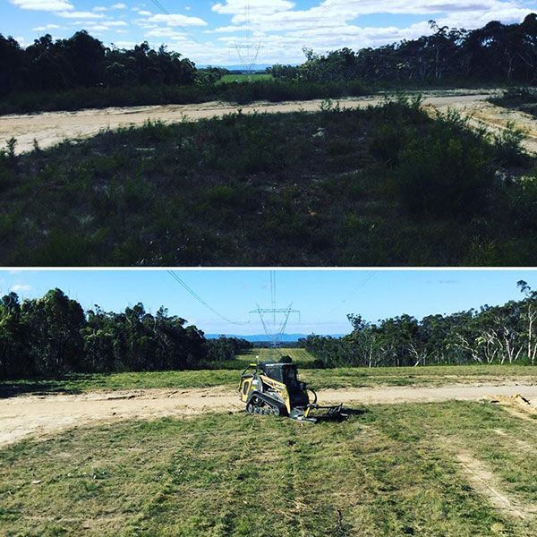 A bulldozer is cutting grass on a dirt road.