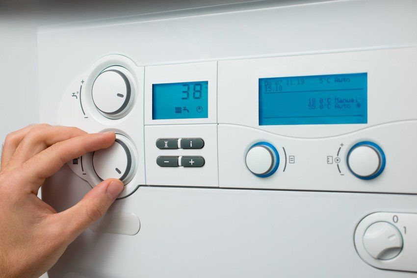Modern digital heating control panel indicating temperature and settings