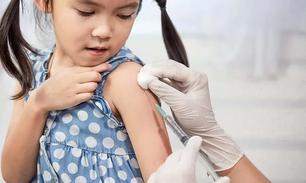 A girl is receiving a vaccination from a pediatrician