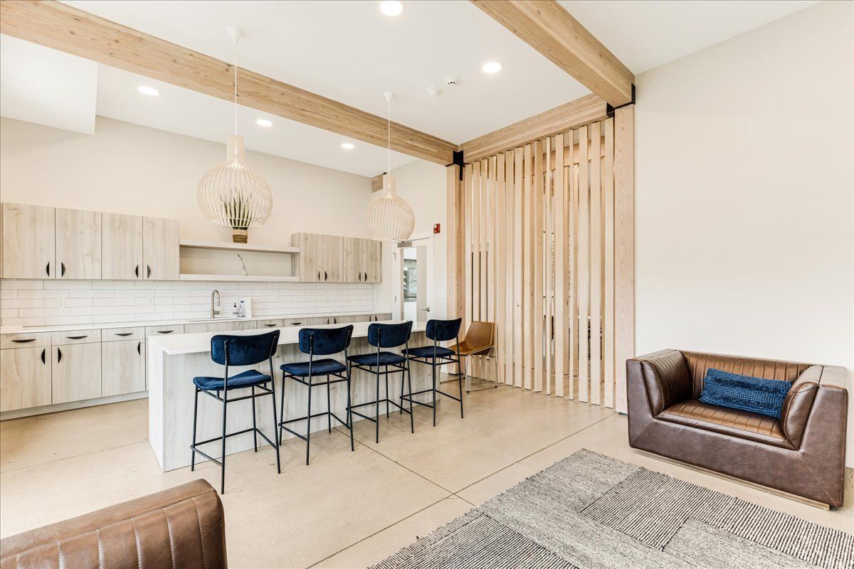 a living room with a couch , chairs , and a kitchen .