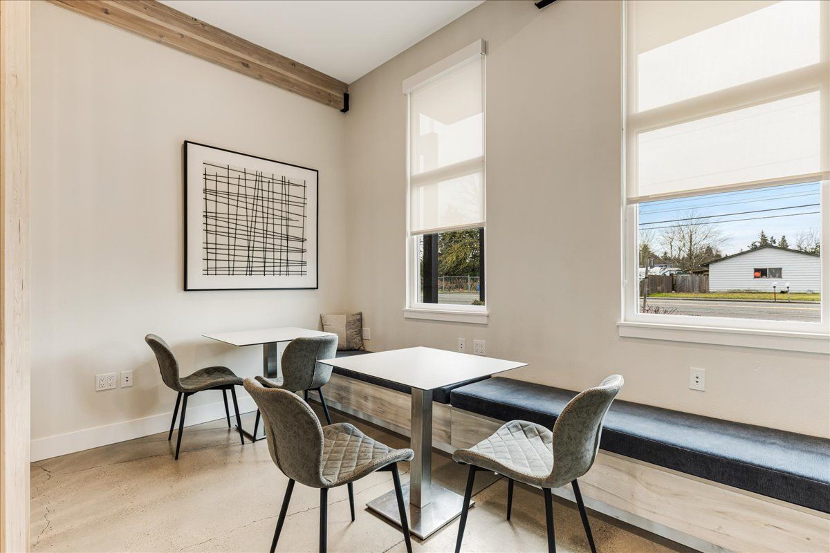 a room with a table and chairs and a window seat .