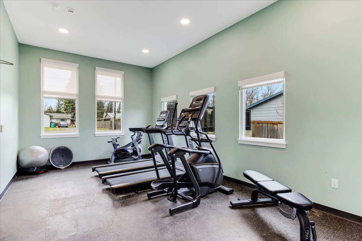 a gym with treadmills , exercise bikes , and a bench .