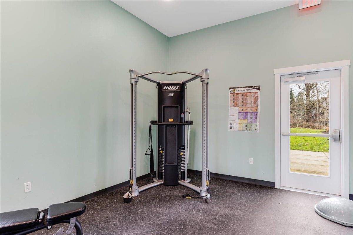 a gym with a machine and a bench in it .