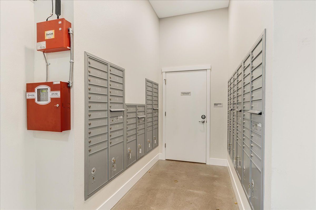 a hallway filled with mailboxes and a fire alarm .