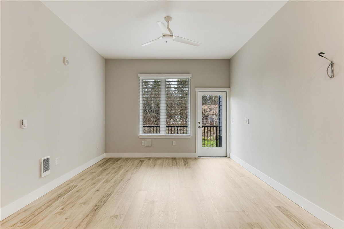 an empty room with hardwood floors and a ceiling fan .
